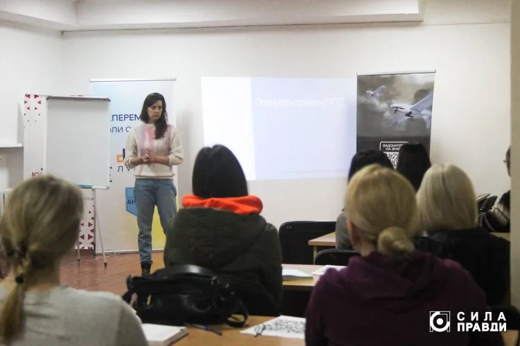 Любава Казмірчук пояснює, як надавати першу психологічну допомогу учасникам тренінгу "Перша психологічна допомога" від Центру готовності цивільних в Луцьку, Волонтерського штабу "Ангар" спільно з фондом Сергія Притули